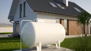 A house with a white water tank placed in front, serving as a storage unit for water supply.